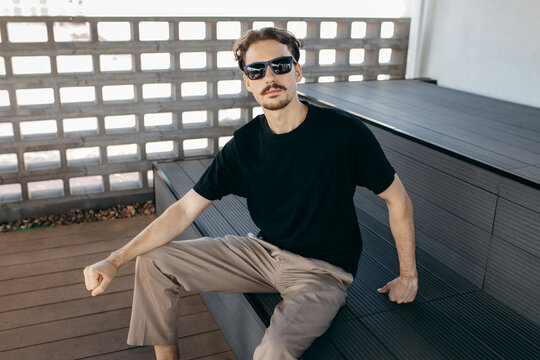 Man wearing black blank t-shirt with space for your logo or design. Mock up	
