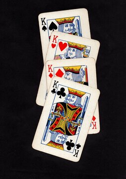 A hand of vintage playing cards isolated on a black background.