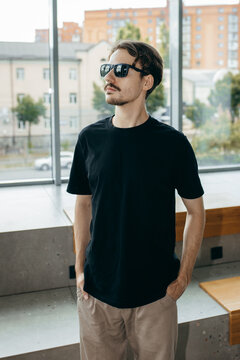 Man wearing black blank t-shirt with space for your logo or design. Mock up	
