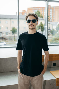 Man wearing black blank t-shirt with space for your logo or design. Mock up	
