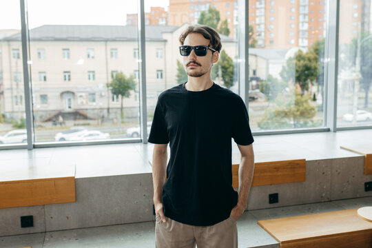 Man wearing black blank t-shirt with space for your logo or design. Mock up	
