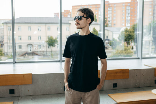 Man wearing black blank t-shirt with space for your logo or design. Mock up	
