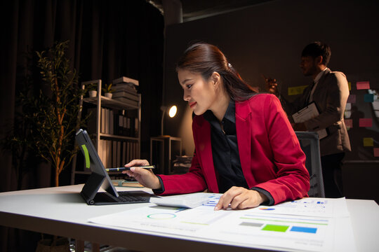 Businesswoman working overtime in the office at night. Accountants are calculating budgets and planning finances. Accounting for income and expenses.