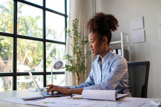 Diligent young woman working in office. Confident young professional woman working diligently in office.