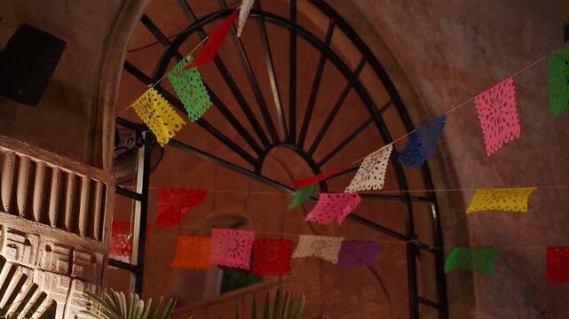Mexican papel picado banners swaying indoors