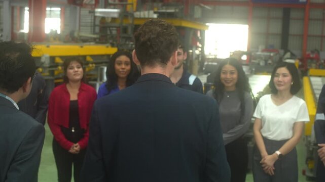 Close-up shot of business partners and industrial engineers shaking hands inside a modern factory. Concept of successful business agreement, international partnership, corporate merger, and B2B manufa