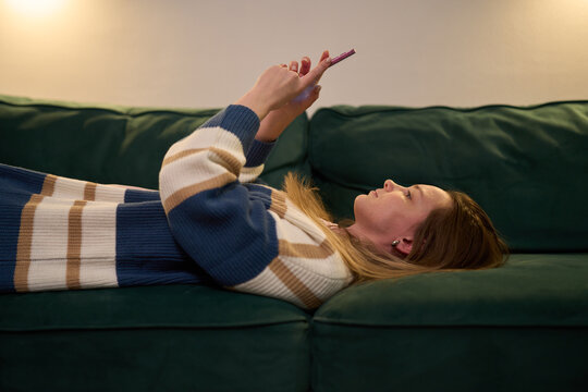 Sleep procrastination with smartphone before bedtime on couch