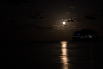 Nocny księżyc odbijający się w odzie oceanu © kubikactive