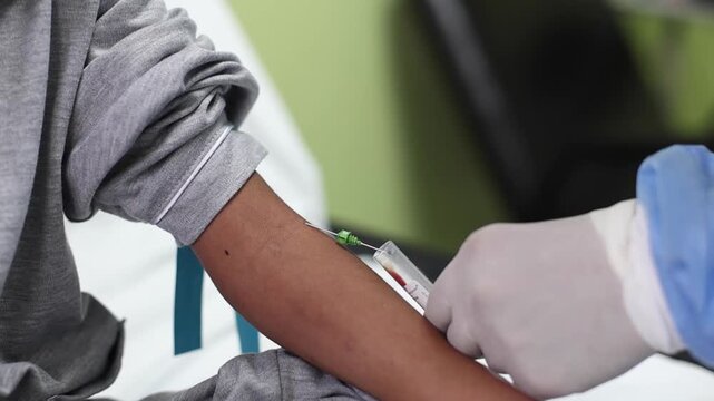 Close-up of blood collection tube held by nurse during medical test