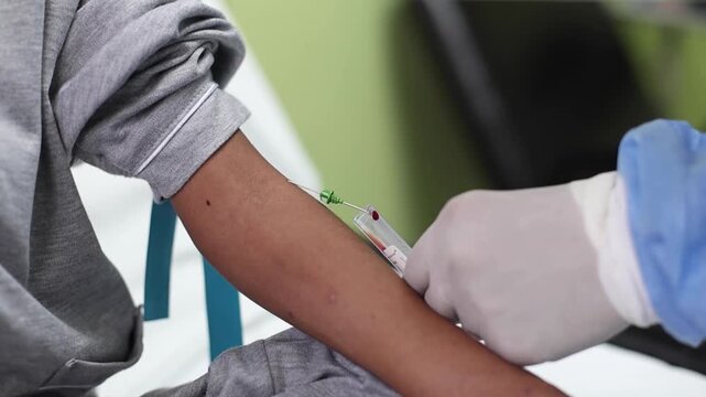 Close-up of nurse collecting blood sample into vacuum tube
