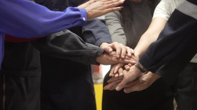Multi-ethnic group of corporate leaders and factory technicians celebrating a successful deal in a manufacturing plant. Perfect for annual corporate reports, international trade commercials, and ESG s