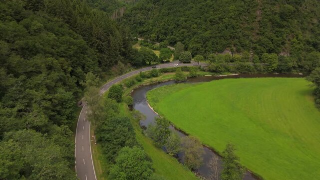 Cars Driving on Valley Road Alongside Sauer River