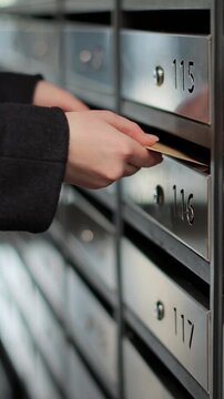 Vertical video Close up woman inserting letter in mailbox. Mail delivery. Mail shipping concept.