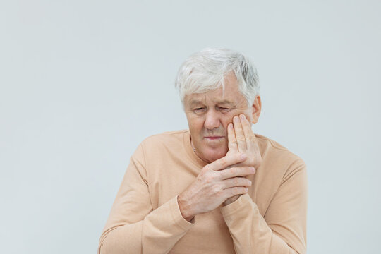 Mature man touching his cheek suffer from toothache