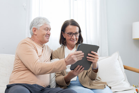 Couple enjoys time together while looking at a tablet in a living room