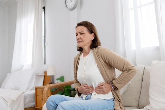 Mature caucasian woman touching her belly suffer from stomach ache