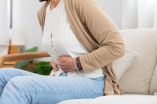 Mature caucasian woman touching her belly suffer from stomach ache