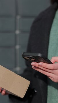 Vertical video Close up woman collecting parcel from shopping locker. Mail delivery and post service, online shopping, e commerce concept.