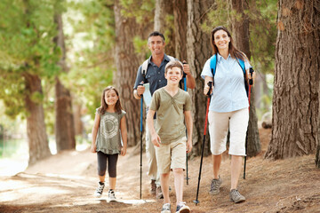 Obraz premium Portrait, parents and children in nature with hiking gear, smile and adventure for bonding together. Happy family, mother and father in woods with kids, trekking and exploration outdoor on holiday.