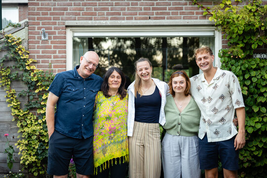 Happy family gathered in a garden outside their home