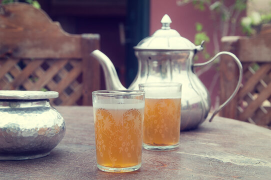Close-up of two glasses of mint tea, a teapot and ashtray on a garden table