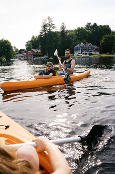family smiling and having fun together on lake in kayaks 