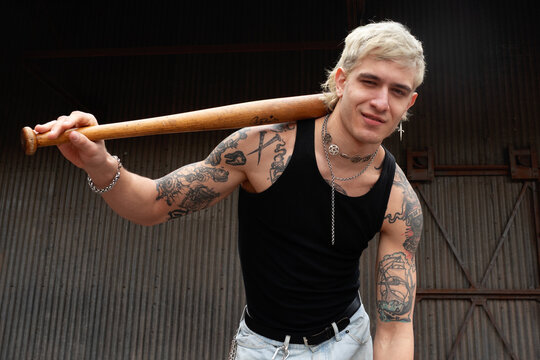 Urban portrait with wooden bat and metal backdrop