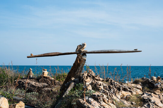 Balanced Driftwood and Rocks Sculpture by the Sea