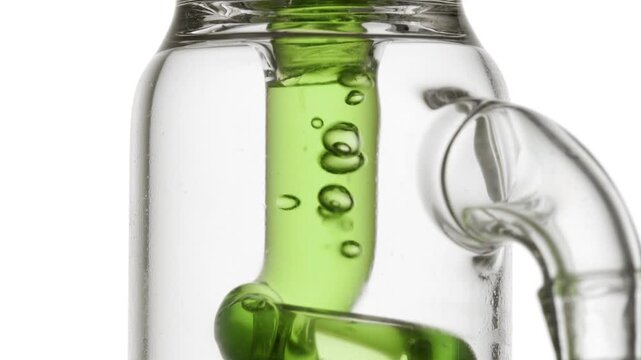 Pale transparent green fluid flowing through a glass tube, causing bubbles to condense and chaotically move inside it over clean white background | Lime peel extract cosmetic mixture concept