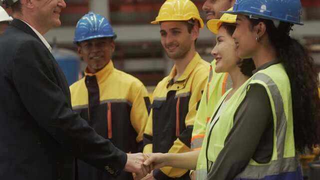 Corporate executives inspecting manufacturing operations while discussing production strategy with engineering professionals and factory workers inside an industrial facility.