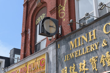 Obraz premium wall-mounted projecting wall clock outside Minh Chau Jewellery located at 352 Spadina Av, Toronto