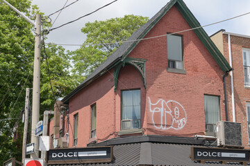 Obraz premium wide view of historic property and sign of Dolce Gelato, an ice cream shop, located at 234 Augusta Av, Kensington Market, Toronto