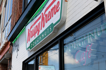 Obraz premium exterior building facade and signs of Krispy Kreme Café, a donut shop chain, located here at 830 College St, Toronto