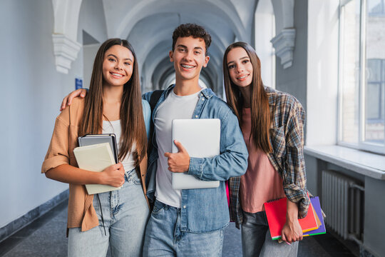 Portrait of high school students looking at camera in school corridor, classmates standing together, education, teamwork, friendship, learning and student life concept