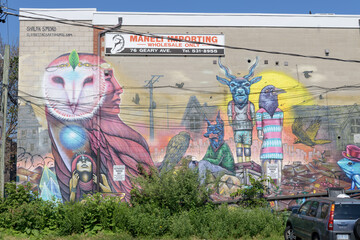 Obraz premium ghost sign of Maneli Importing Inc on the exterior block wall of 76 Geary Av, featuring mural by The Clandestinos, Shalak Attack and Smoky, called “Diamonds of Extinction”, Toronto