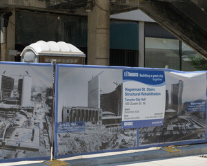 Obraz premium Hagerman Street staircase construction site hoarding with mesh banner featuring historical images of City Hall, Toronto