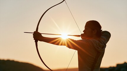Fototapeta na wymiar Man holding bow and arrow aiming at sun