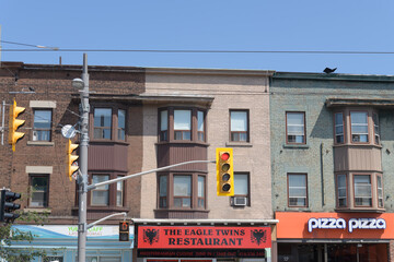 Obraz premium historic commercial block (with apartments above) on St Clair Av W including signs of Yummi Café Laundromat, The Eagle Twins hamburger restaurant, and Pizza Pizza, Toronto