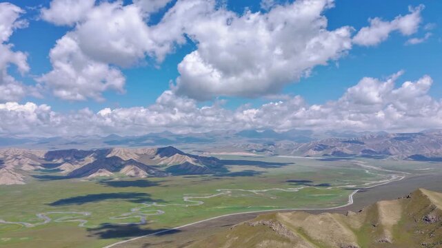 A stunning aerial drone shot of a vast valley with lush green meadows.