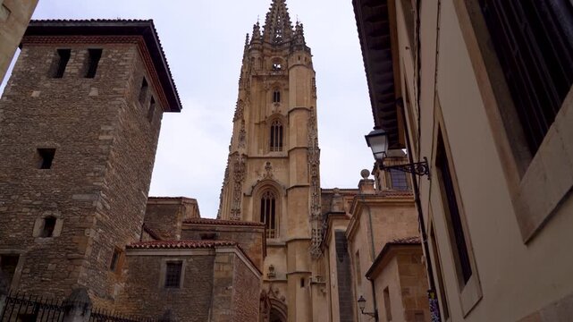 Torre de la Catedral de Oviedo visible entre los edificios del casco antiguo, destacando sobre la arquitectura hist&oacute;rica del centro de la ciudad.