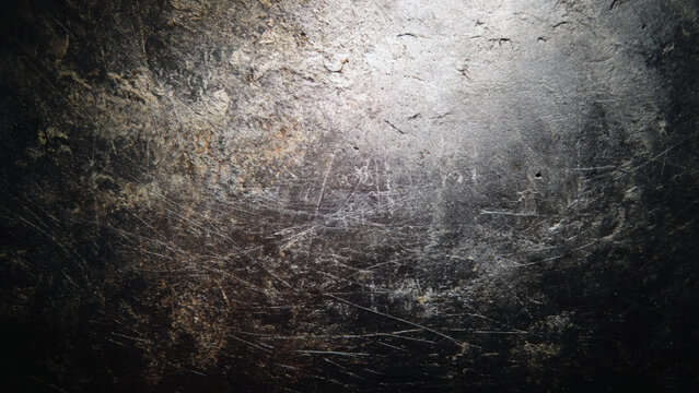 Scratched and weathered metal surface with rough texture and faded marks