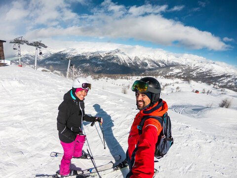 Happy couple enjoying winter skiing on a mountain resort