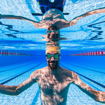 Male swimmer underwater smiling in swimming pool