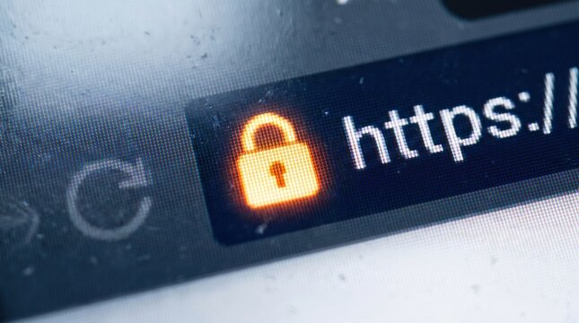 Macro close up of a secure web browser address bar displaying the https protocol and glowing padlock icon