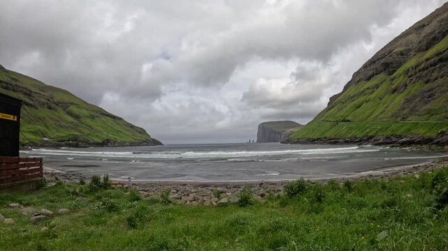 Static wide shot of Tjornuvik black sand beach and Risin og Kellingin stacks, Faroe Islands