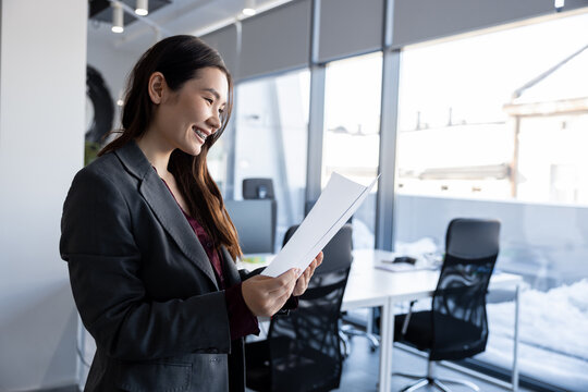 Long-haired woman in the office analyzing documents for new project