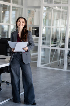 Long-haired woman in the office analyzing documents for new project