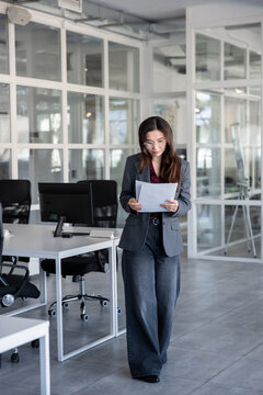 Long-haired woman in the office analyzing documents for new project