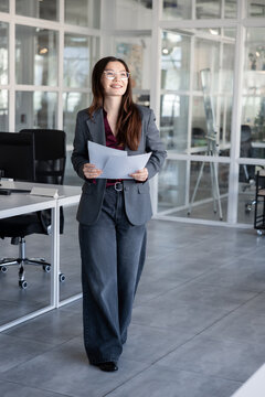 Young woman holding documents in hands and looking contented