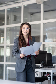 Young woman holding documents in hands and looking contented